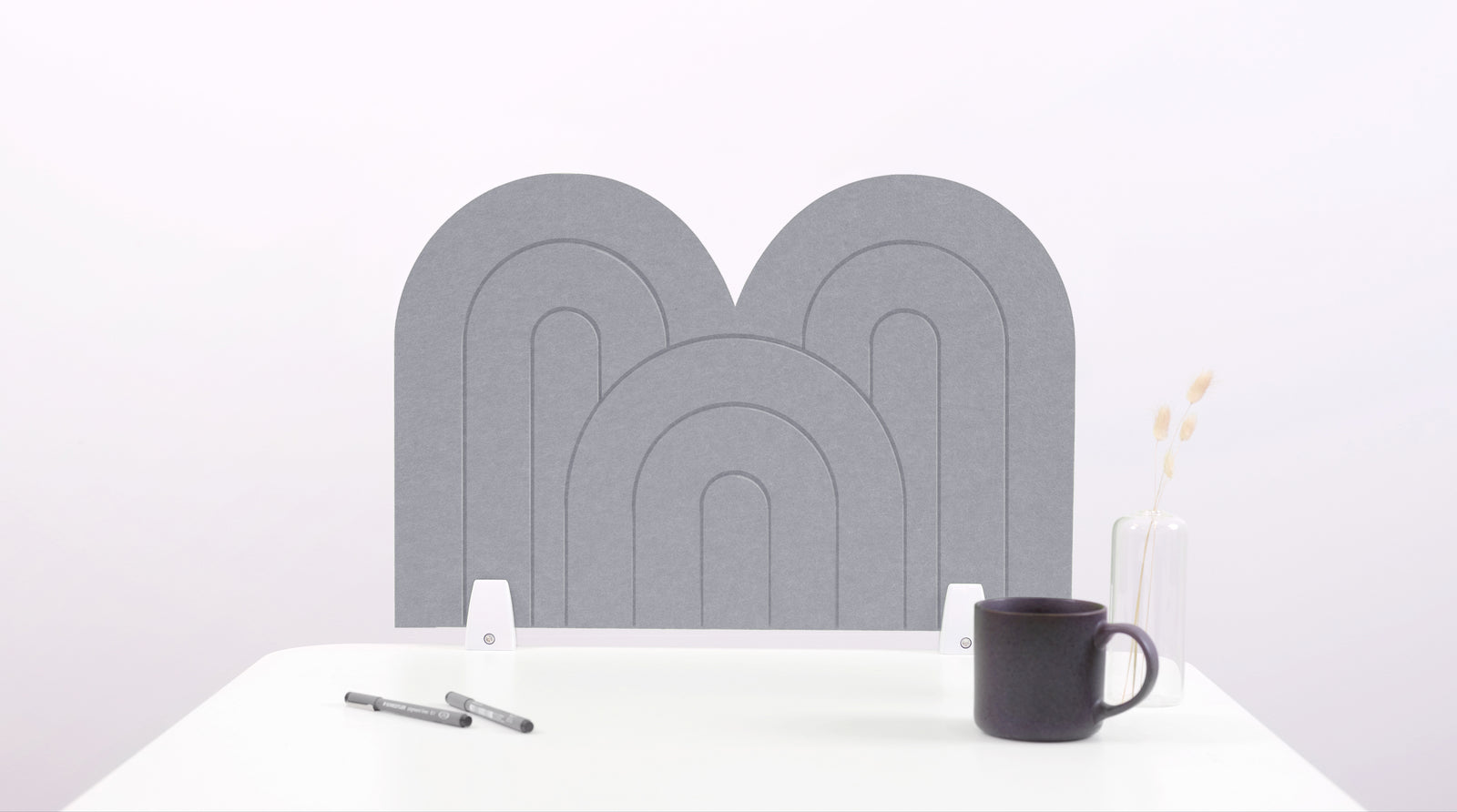 A light gray arch-shaped desk divider on a white desk. For the side of your desk.