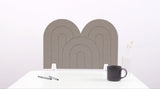 A brown arch-shaped desk divider on a white desk. For the side of your desk.