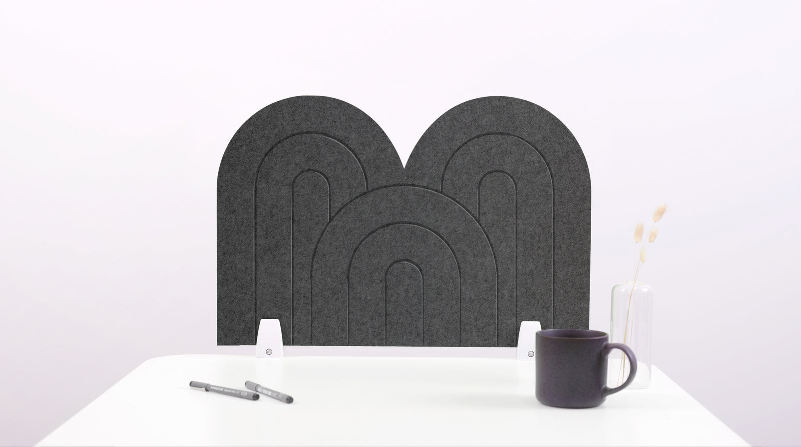 A dark gray arch-shaped desk divider on a white desk. For the side of your desk.