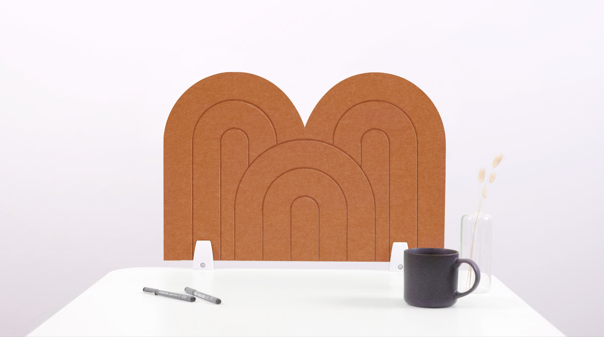 A cinnamon colored felt desk divider with a scalloped design of lines and arches. 