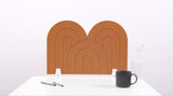 A cinnamon colored felt desk divider with a scalloped design of lines and arches. 