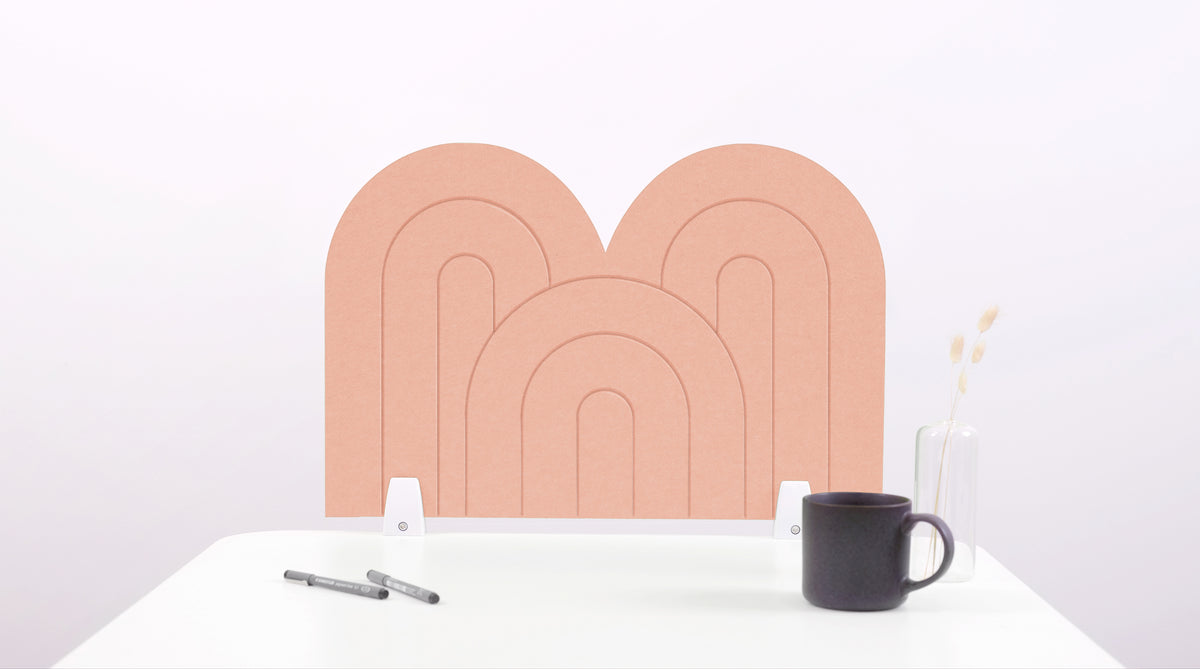 A coral pink arch-shaped desk divider on a white desk. For the side of your desk.