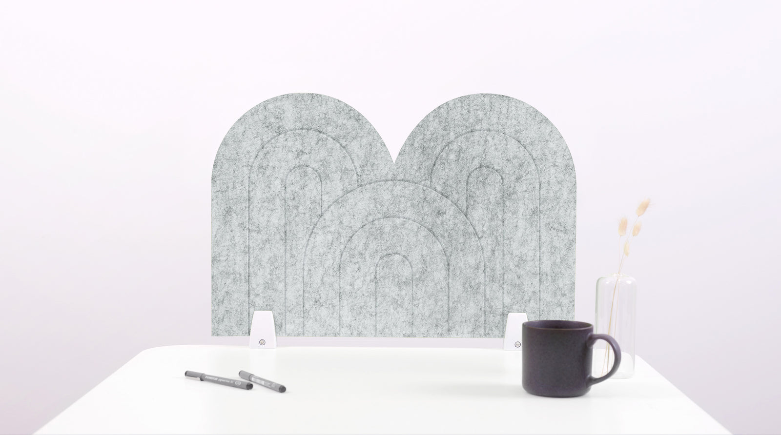 A nickel colored arch-shaped desk divider on a white desk. For the side of your desk.
