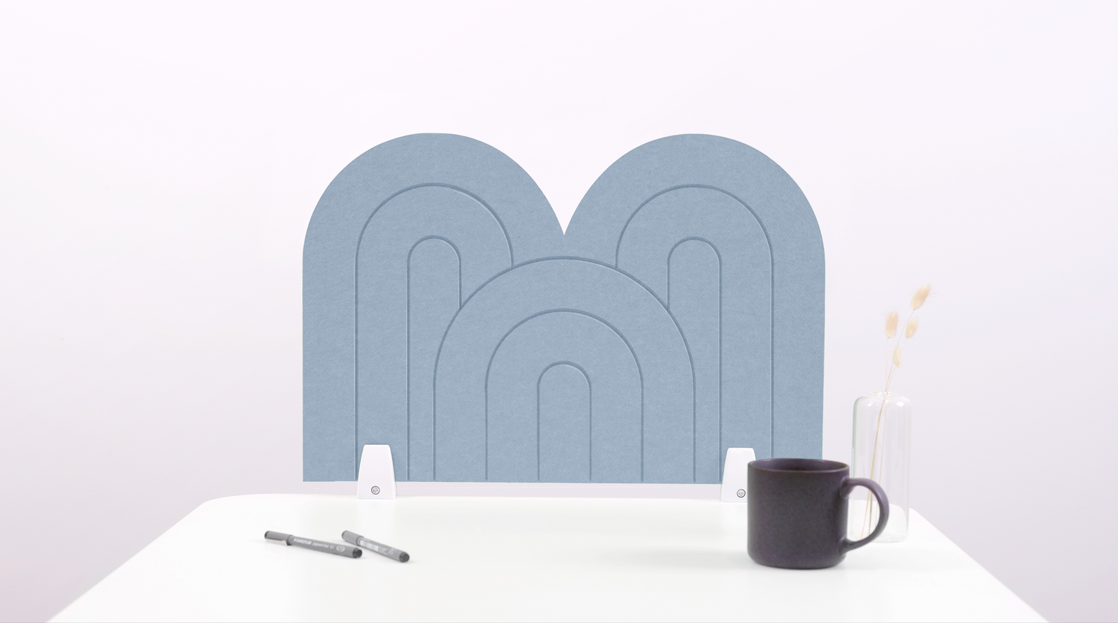 A light blue arch-shaped desk divider on a white desk. For the side of your desk.