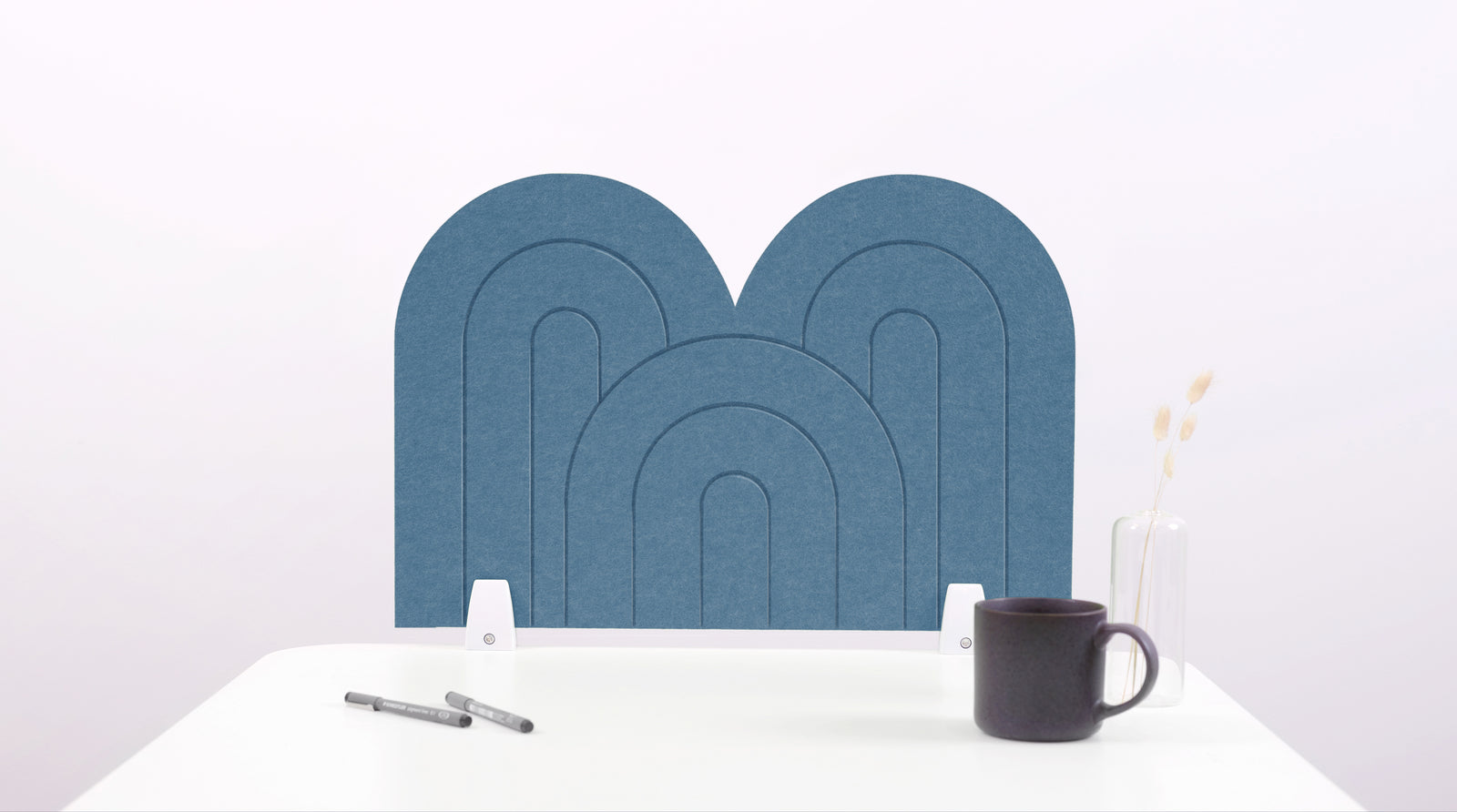 A slate blue arch-shaped desk divider on a white desk. For the side of your desk.