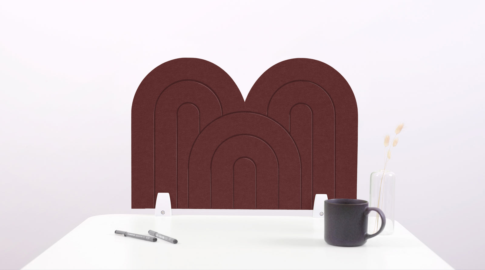 A brown arch-shaped desk divider on a white desk. For the side of your desk.