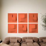 Orange acoustic felt tiles with points of dimension on a wall above a brown couch