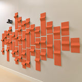 Orange acoustic felt tiles with 3d peaks along a wall