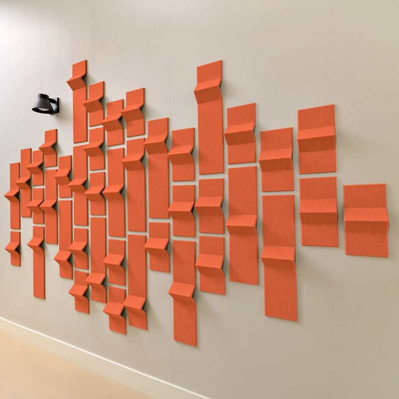 Orange acoustic felt tiles with 3d peaks along a wall