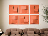 Six terracotta tiles with dimensional cutouts and layered geometric shapes arranged in a grid above a beige sofa.