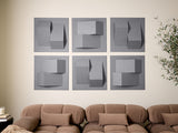 Six gray dimensional wall tiles with geometric cutouts and layered surfaces arranged in a grid above a tan sofa.