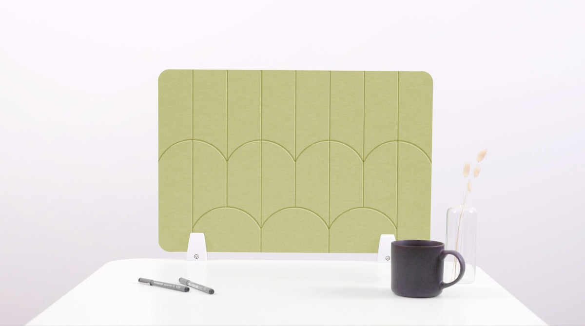 A light green colored felt desk divider with a scalloped design of lines and arches. 
