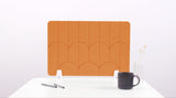 An orange colored felt desk divider with a scalloped design of lines and arches. 