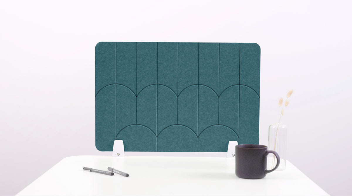 A teal blue colored felt desk divider with a scalloped design of lines and arches. 