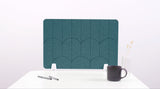 A teal blue colored felt desk divider with a scalloped design of lines and arches. 