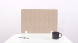 A tan colored felt desk divider with a scalloped design of lines and arches. 
