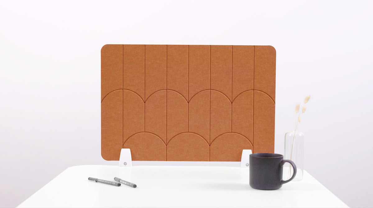 A cinnamon colored felt desk divider with a scalloped design of lines and arches. 