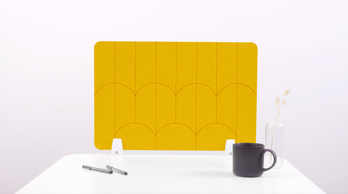 A yellow colored felt desk divider with a scalloped design of lines and arches. 