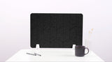 A black felt desk divider with a scalloped design of lines and arches. 