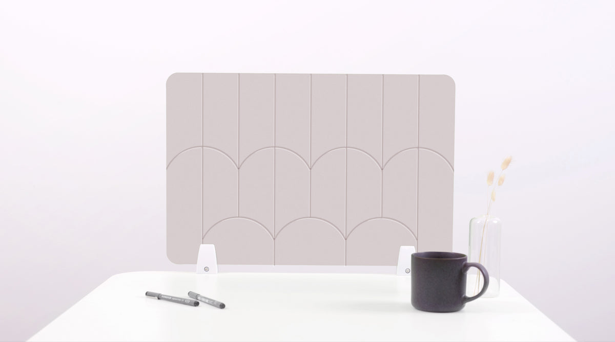 A white colored felt desk divider with a scalloped design of lines and arches. 
