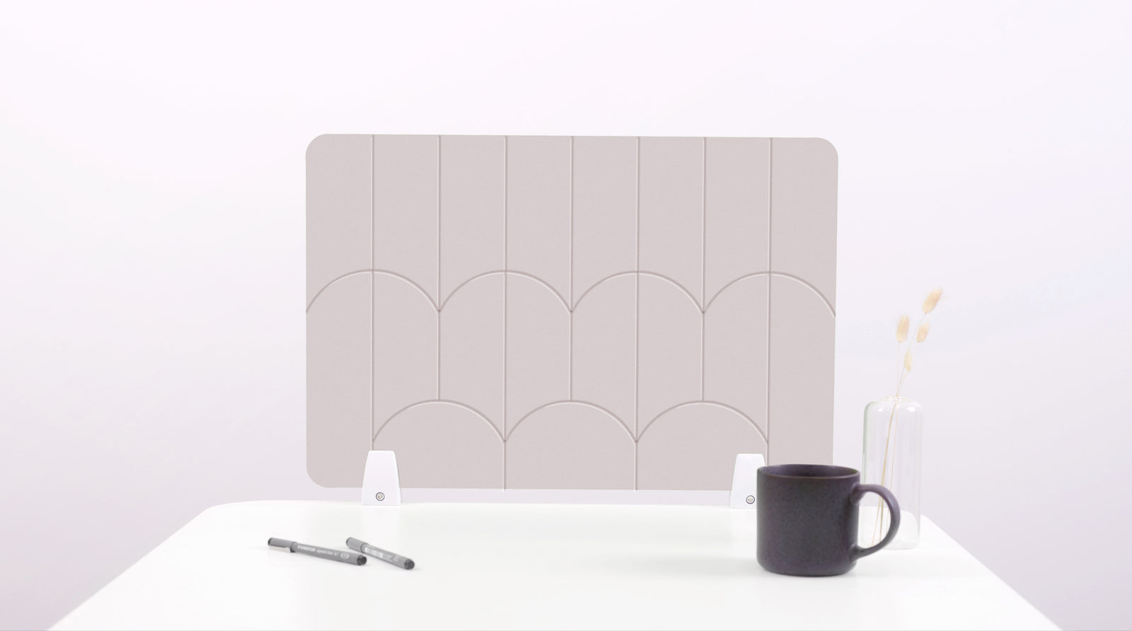 A white colored felt desk divider with a scalloped design of lines and arches. 
