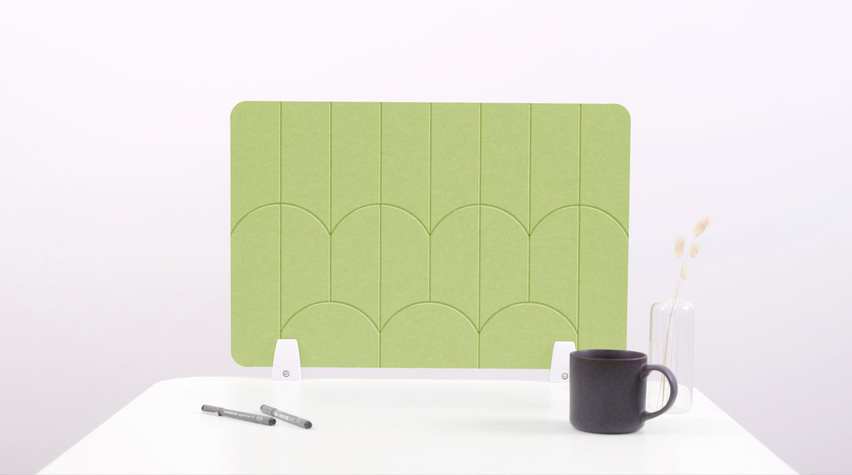 A light green colored felt desk divider with a scalloped design of lines and arches. 