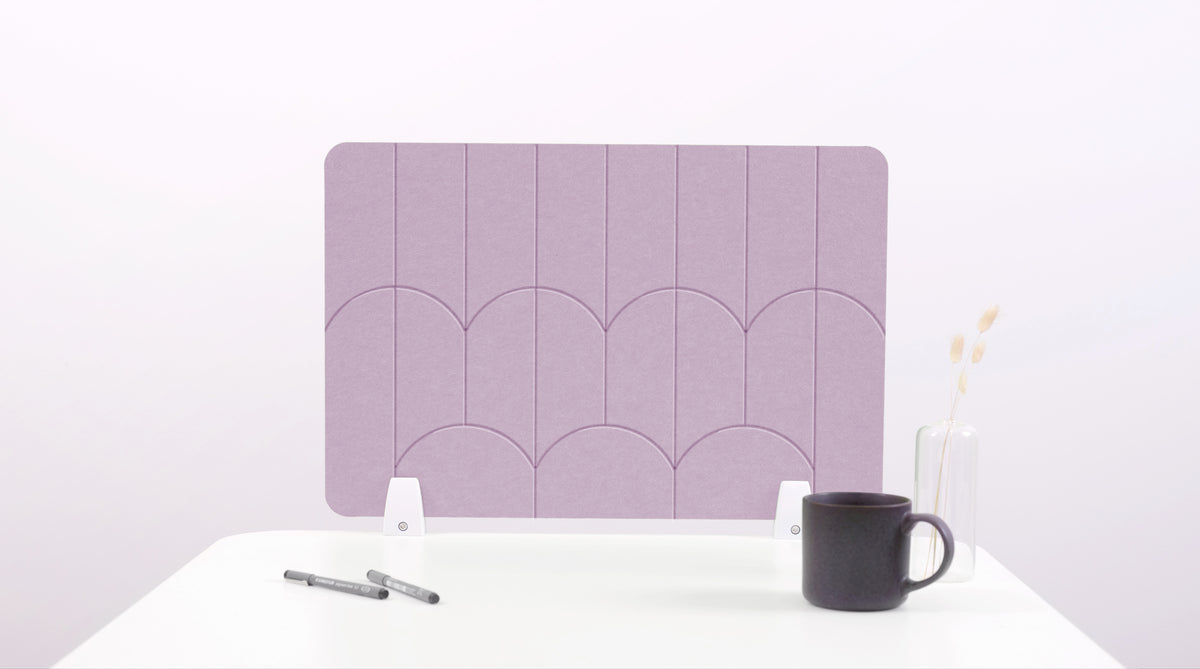 A lilac pink colored felt desk divider with a scalloped design of lines and arches. 