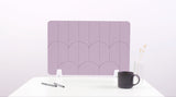 A lilac pink colored felt desk divider with a scalloped design of lines and arches. 