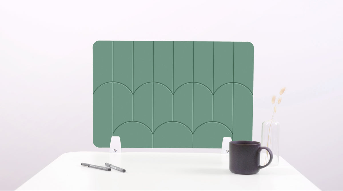 A mint green colored felt desk divider with a scalloped design of lines and arches. 