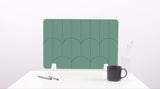 A mint green colored felt desk divider with a scalloped design of lines and arches. 