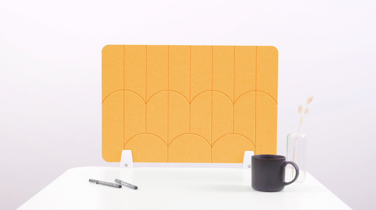 A mustard yellow colored felt desk divider with a scalloped design of lines and arches. 