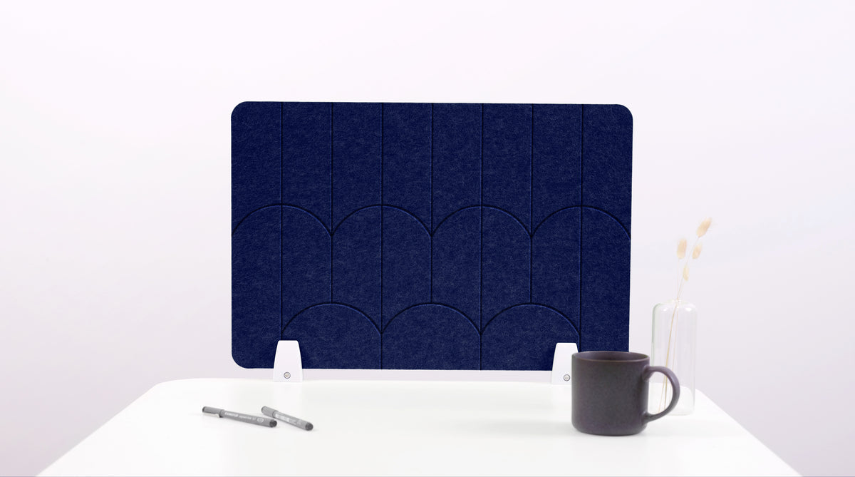 A navy blue colored felt desk divider with a scalloped design of lines and arches. 