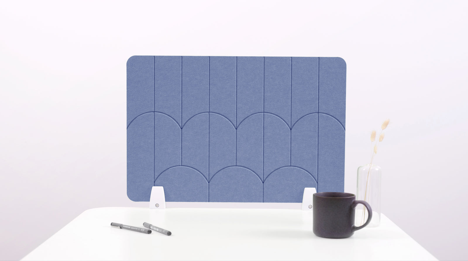 A blue/purple colored felt desk divider with a scalloped design of lines and arches. 