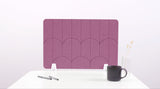 A pink colored felt desk divider with a scalloped design of lines and arches. 