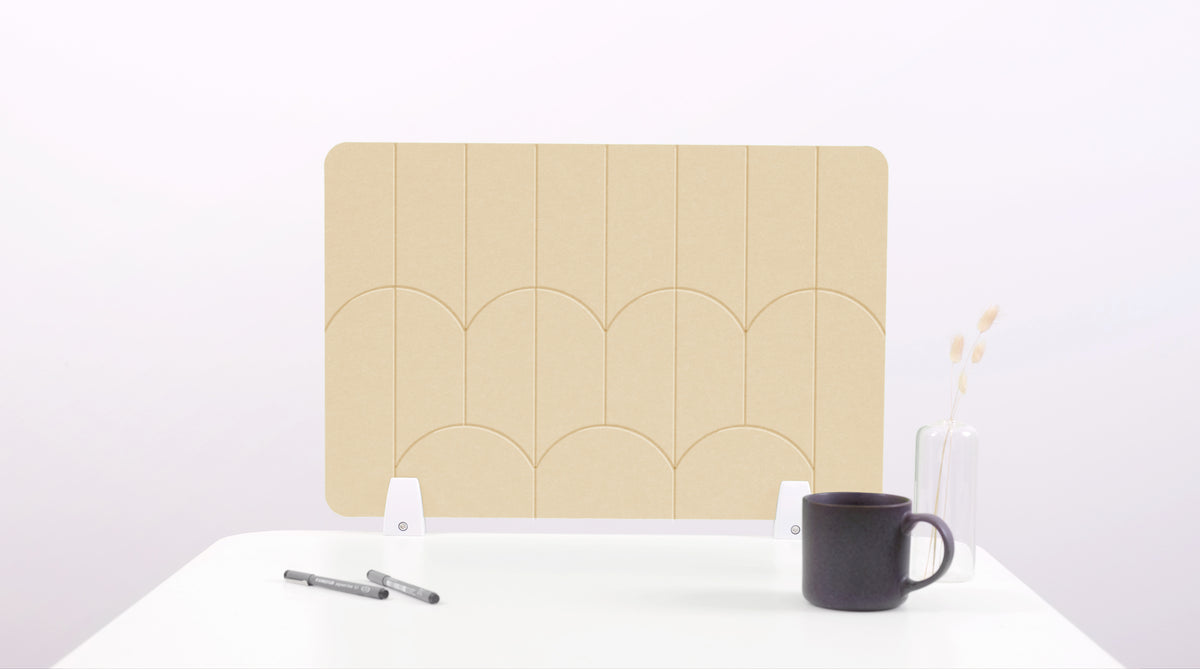 A light tan colored felt desk divider with a scalloped design of lines and arches. 