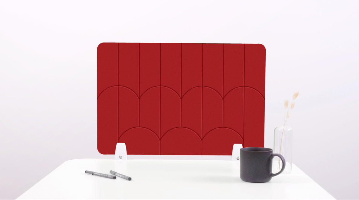 A red colored felt desk divider with a scalloped design of lines and arches. 