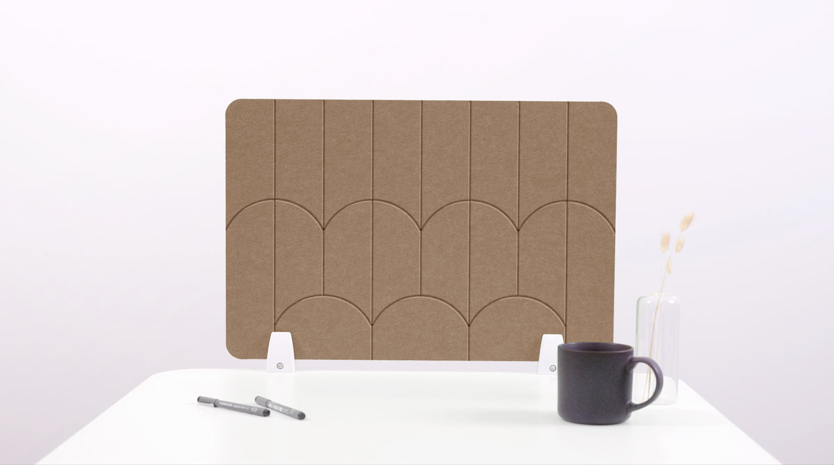 A brown colored felt desk divider with a scalloped design of lines and arches. 