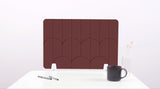 A dark brown colored felt desk divider with a scalloped design of lines and arches. 