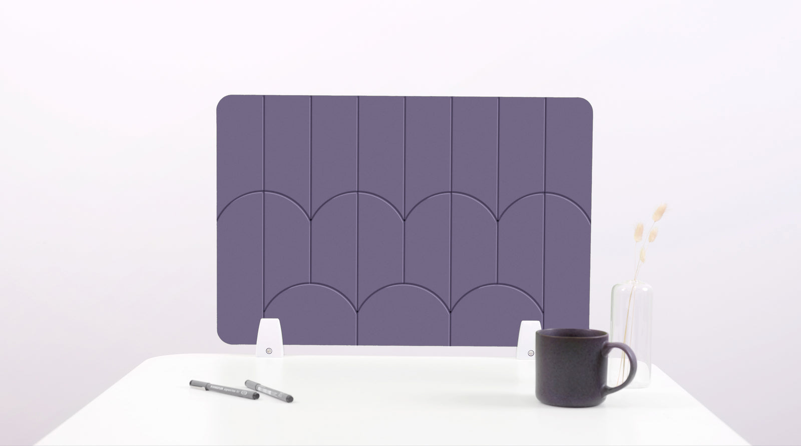 A purple colored felt desk divider with a scalloped design of lines and arches. 