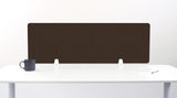 A dark brown felt desk divider with a scalloped wave pattern, mounted on a white desk with a black mug on the left and a small notepad on the right.