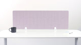 A lilac pink colored felt desk divider with a scalloped wave pattern, mounted on a white desk with a black mug on the left and a small notepad on the right.
