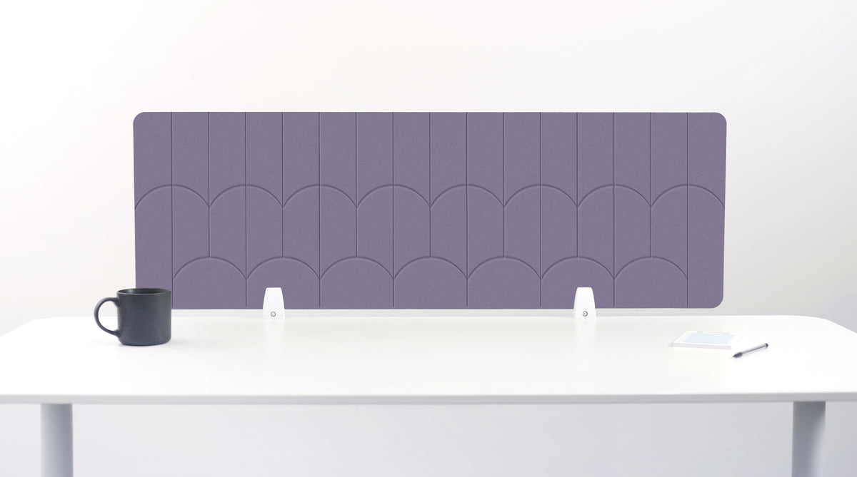 A rectangular desk divider with a purple scallop pattern, displayed on a white desk with a black mug and small accessories.