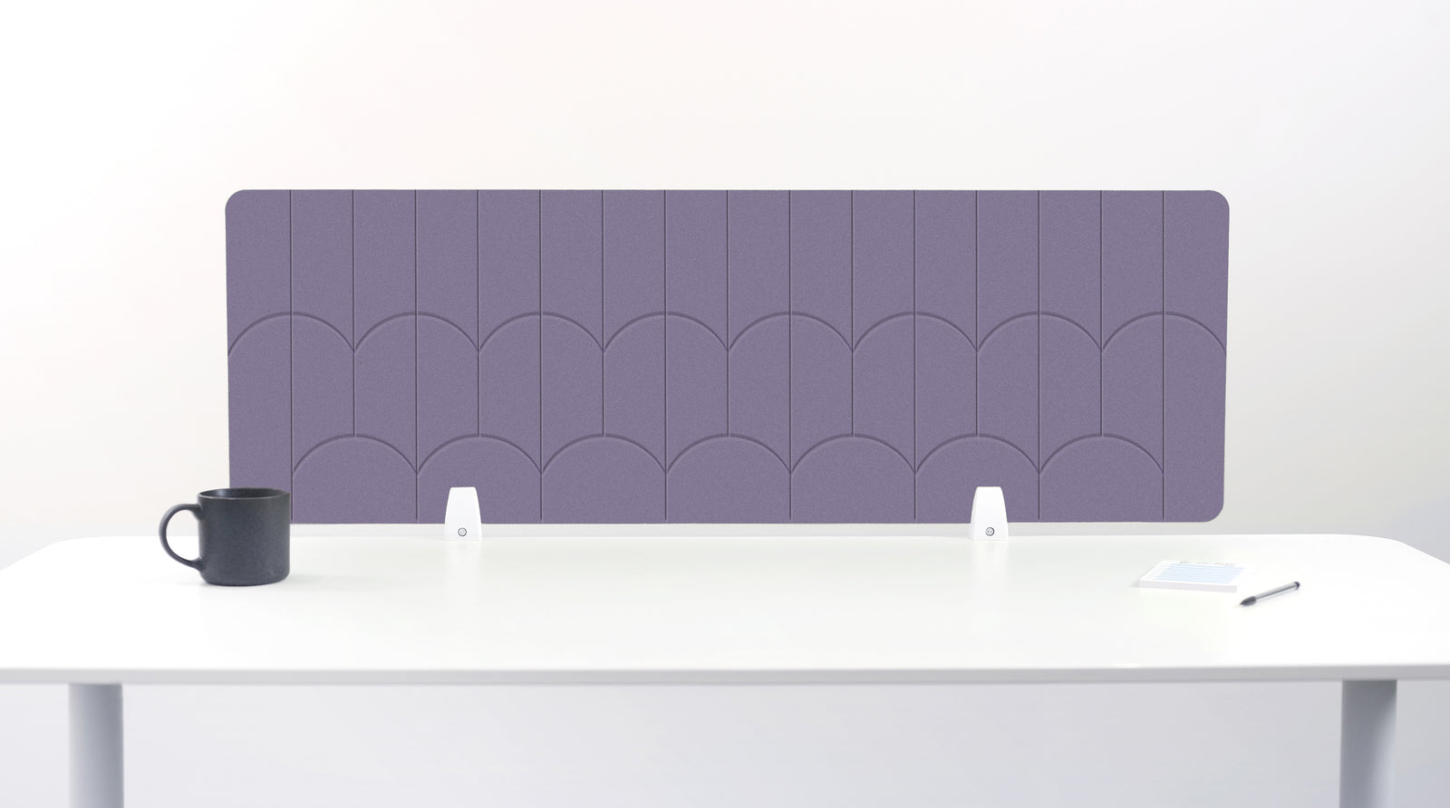A rectangular desk divider with a purple scallop pattern, displayed on a white desk with a black mug and small accessories.