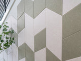 Chevron patterned wall tiles in cream and sage green with three-dimensional faceted surface.