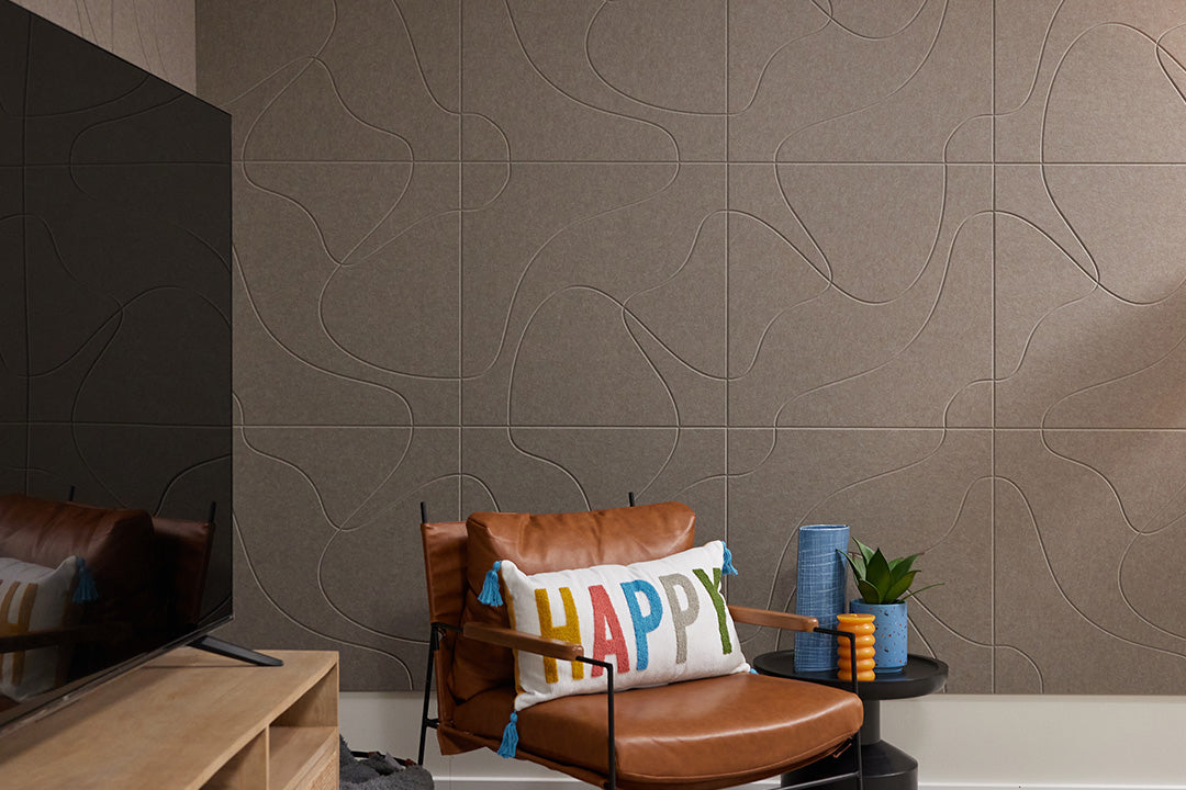 Brown acoustic wall panels on wall behind chair and tv