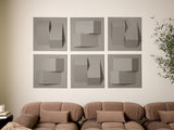Set of six gray dimensional wall tiles with varied geometric cutouts and raised surfaces arranged in a grid above a tan sofa.