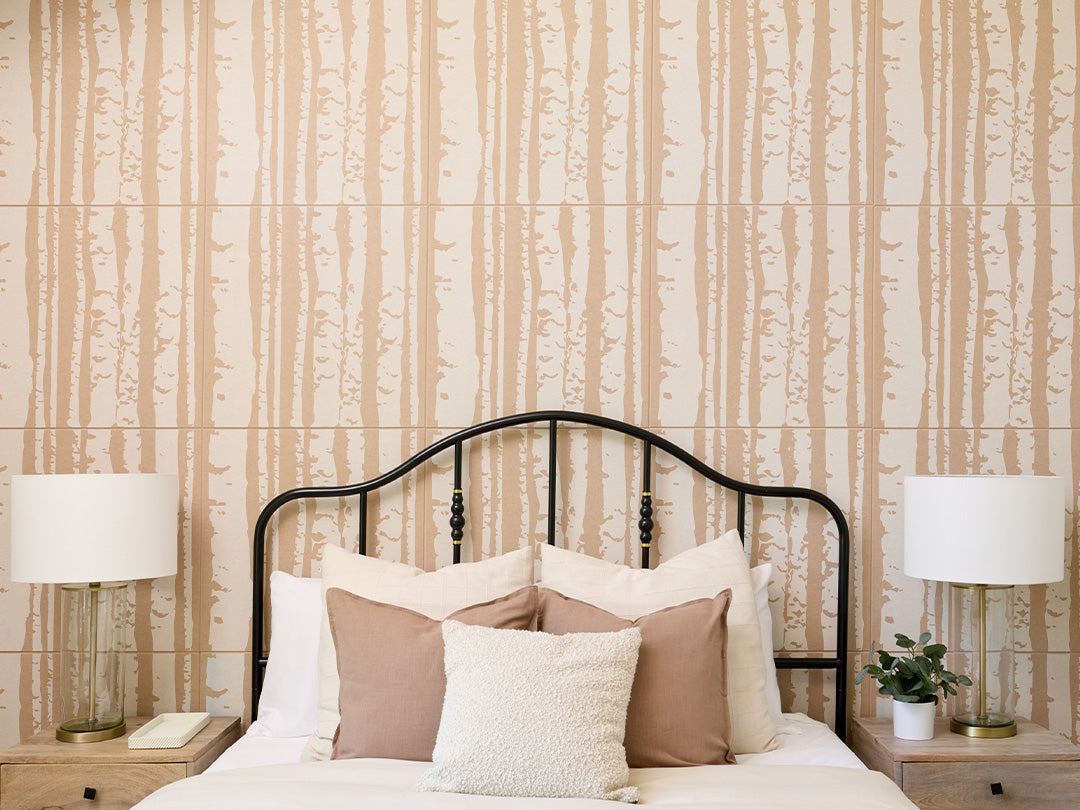 Cashmere colored Felt Right 2' x 2' tiles with white printed patterns in the shape of aspen tree trunks. There is a bed, two night stands, and two lamps in the foreground.