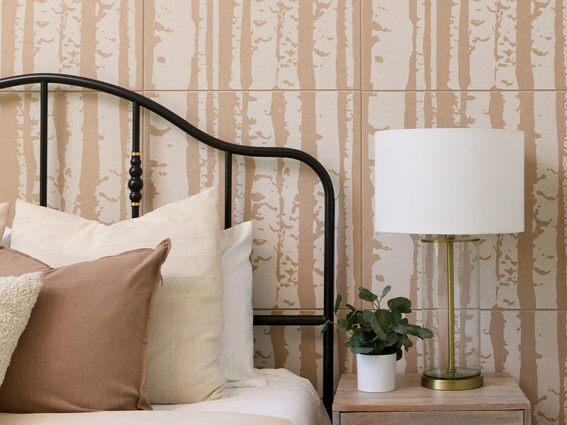 Close up shot of the Felt Right printed aspen tiles on Cashmere colored acoustic panels. There is a bed, night stand, and a lamp in the foreground.