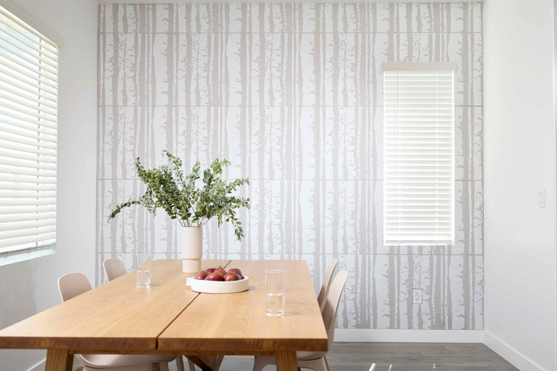 Dining room with wooden table, chairs, and decorative elements against a patterned wall.