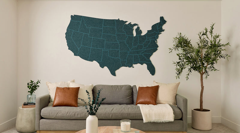 Living room with a gray sofa, decorative pillows, and a wall map of the United States.